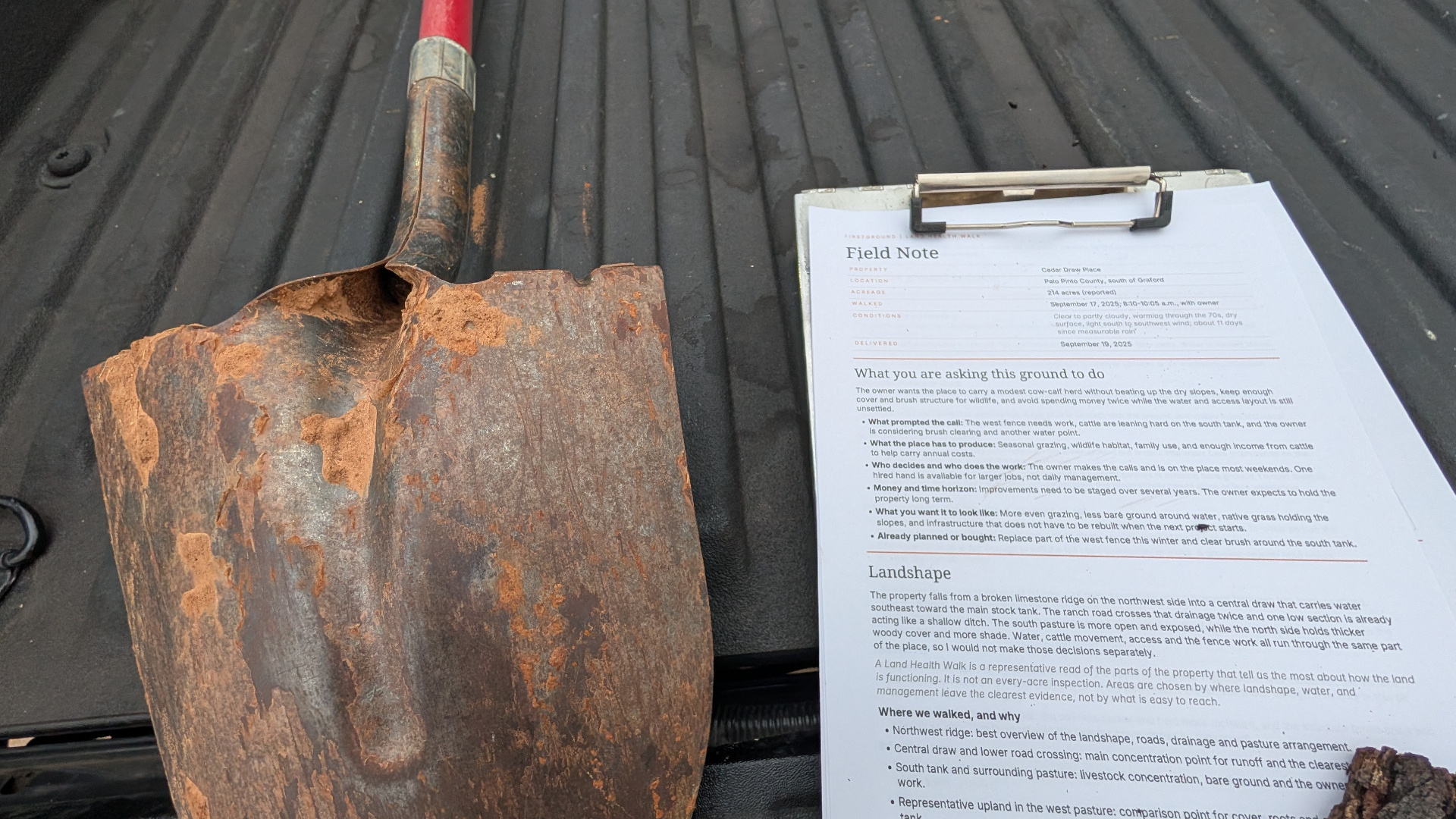 Rusty shovel beside a Firstground Land Health Walk field note on a pickup truck bed