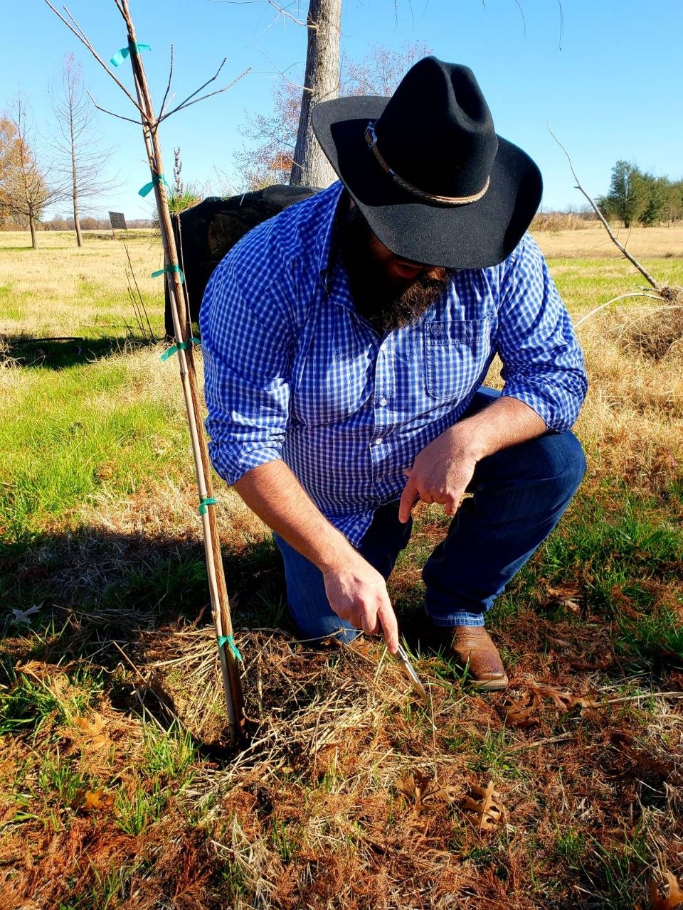 Bear Shaw of Firstground examining soil and plant health at a North Central Texas property